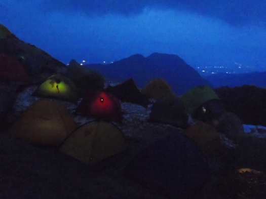 Returning to camp---headlamps in tents, and the lights of the city beyond.