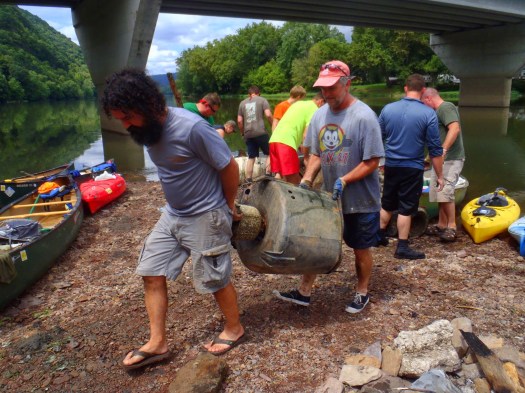 Tony and Greg work together to move a washing machine.